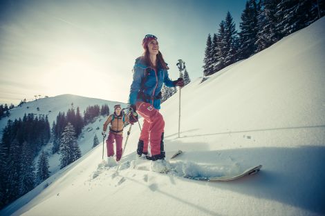 Zwei Personen im Schnee mit Skiern unterwegs